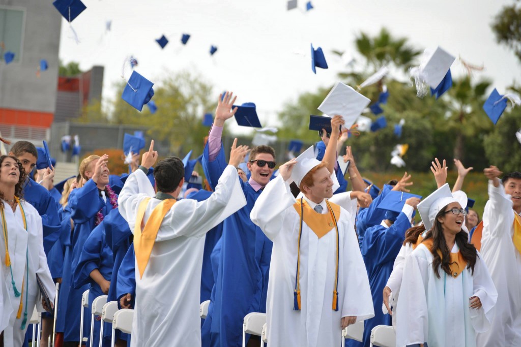 Graduates throw their caps. Photo credit: Ashley Le