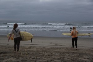 Colleen Millican and Delaney Millican head into the water for the women's long board competition.  Photo by Alex Doan