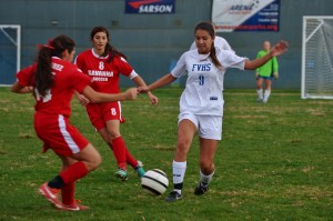 Makena Walker ('16) battles for the ball against Savanna players. Photo by Ashley Le.