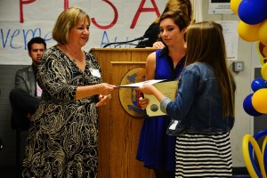 Consumer and Family Studies Department Coordinator Kerry Doll hands the award to Leigha Williams ('16). 