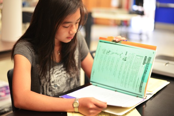 Vi Co ('17) uses tab dividers in order to help with organizing paperwork from various classes instead of having multiple binders. Photo by Ashley Le. 