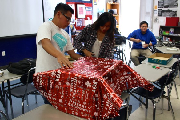 Red Cross members wrapping boxes up in wrapping paper for their Toy Drive. Photo by: Heather Kim 