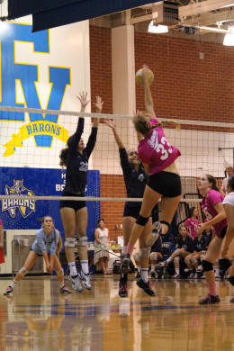 Middle blocker Rilyn Todd ('17) reaches high over the double block and earns a kill for the Barons. Photo by Michelle Nhi Nguyen