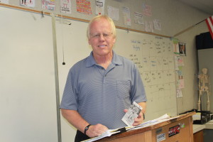 U.S Government teacher Eric Johnson holds a photo of himself playing of the Philadelphia Eagles. 