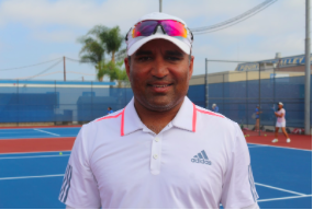 Harshul Patel, the varsity girls tennis coach of FVHS, smiles towards the successful season that the team is going to have this year. Photo by Calvin Tran. 