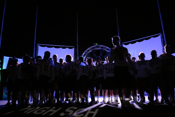 The football varsity team stands proudly on stage in front of their fellow supporting students. Photo by Sandra On 