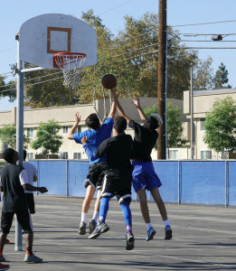 Players from team Bomb Squad and team Cu Den Dynasty attempt to catch a rebound. Photo by Elise Tran