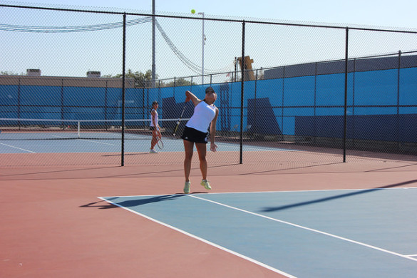 Doubles no. 1 Co-Captain Clarissa Htay ('17) takes her racket back and jumps up to serve the ball. Photo by Ivy Duong, Staff Photographer.