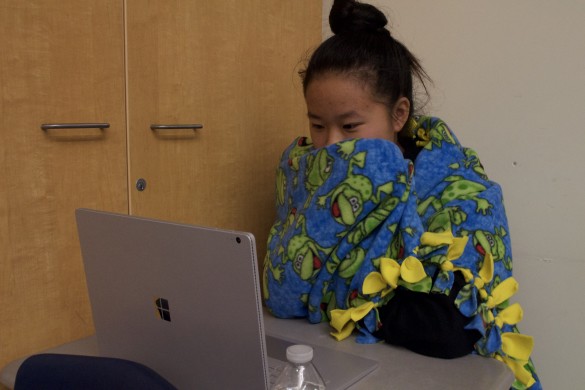 Brigitte Doan ('18) wraps herself in a blanket as the temperature in the classroom is too cold for her preferences. Photo by John Le. 