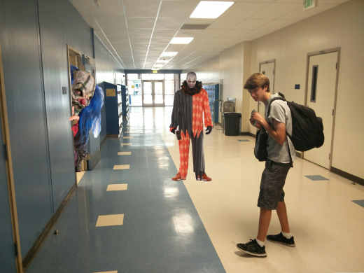 Daniel Sanders ('18) walking through the hallway, unaware that two clowns are watching him.