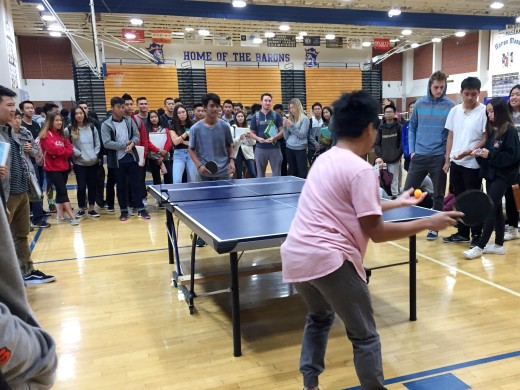 Two students battle it out on the ping pong table. 